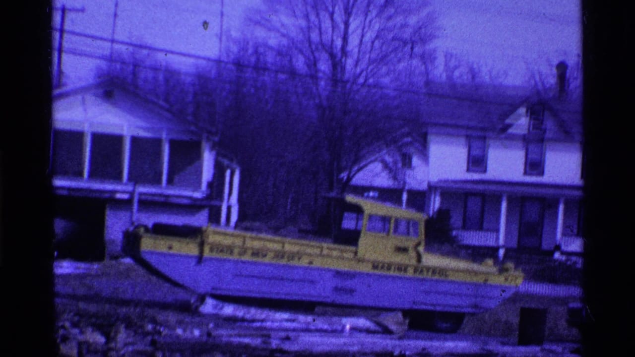 1969 Ohio frame with a yellow State of Ohio Marine Patrol vehicle near residential houses, bare trees, and snow-covered ground.