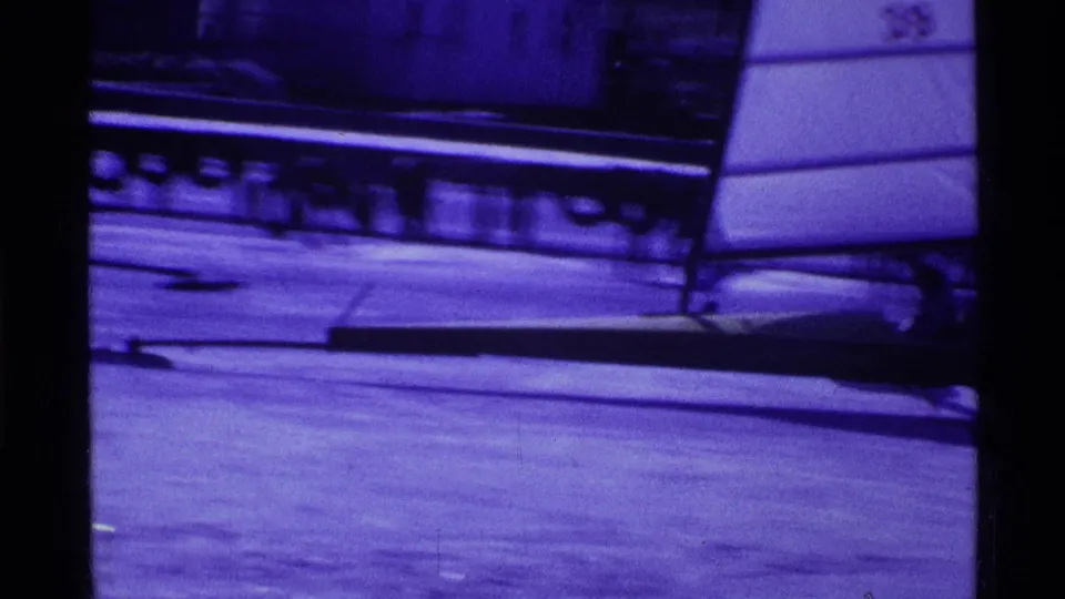 1969 Ohio 8mm frame showing a white sail and low ice-sailing craft resting on a frozen lake surface.