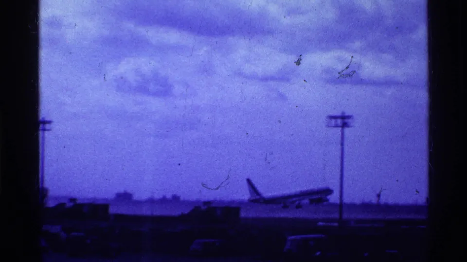The commercial airliner appears to lift off from the Ohio airport runway in 1969, seen in soft blue 8mm footage with visible grain.