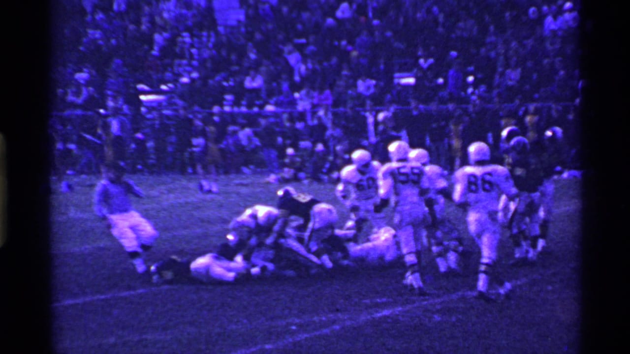 1969 Ohio 8mm frame showing helmeted football players around a tackle on a grass field, with crowded stands in the background.