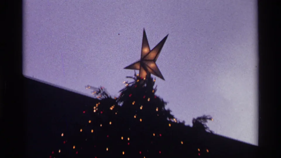 Close 1970 New York City home-movie view of the illuminated star topping the Rockefeller Center Christmas tree.