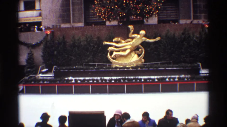 1970 New York City frame of the Rockefeller Center rink area, showing the gold Prometheus sculpture and winter visitors below.