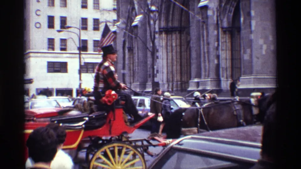 1970 New York City street view with a plaid-shirted carriage driver in a top hat guiding a dark horse past cars and pedestrians.