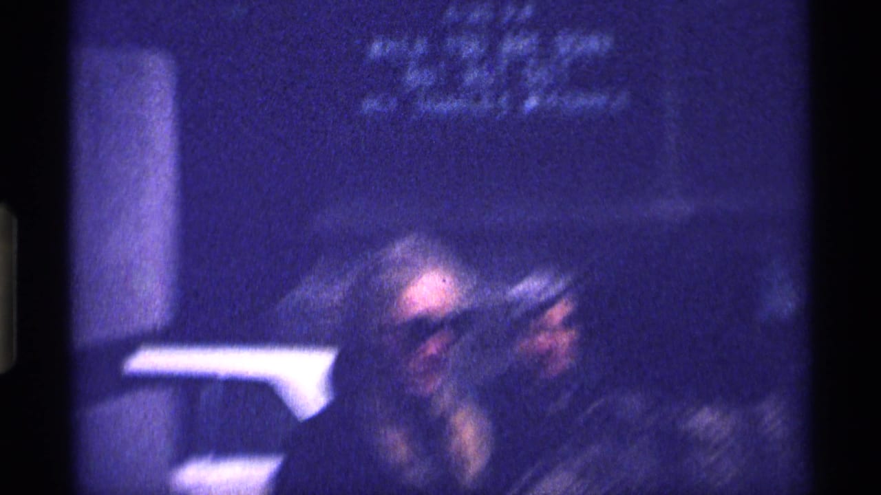 Soft, blue-tinted frame with a blurred figure near a wall or column.