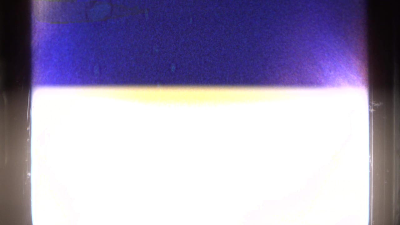 Overexposed film frame with purple-blue color cast and dark vertical gate edges.