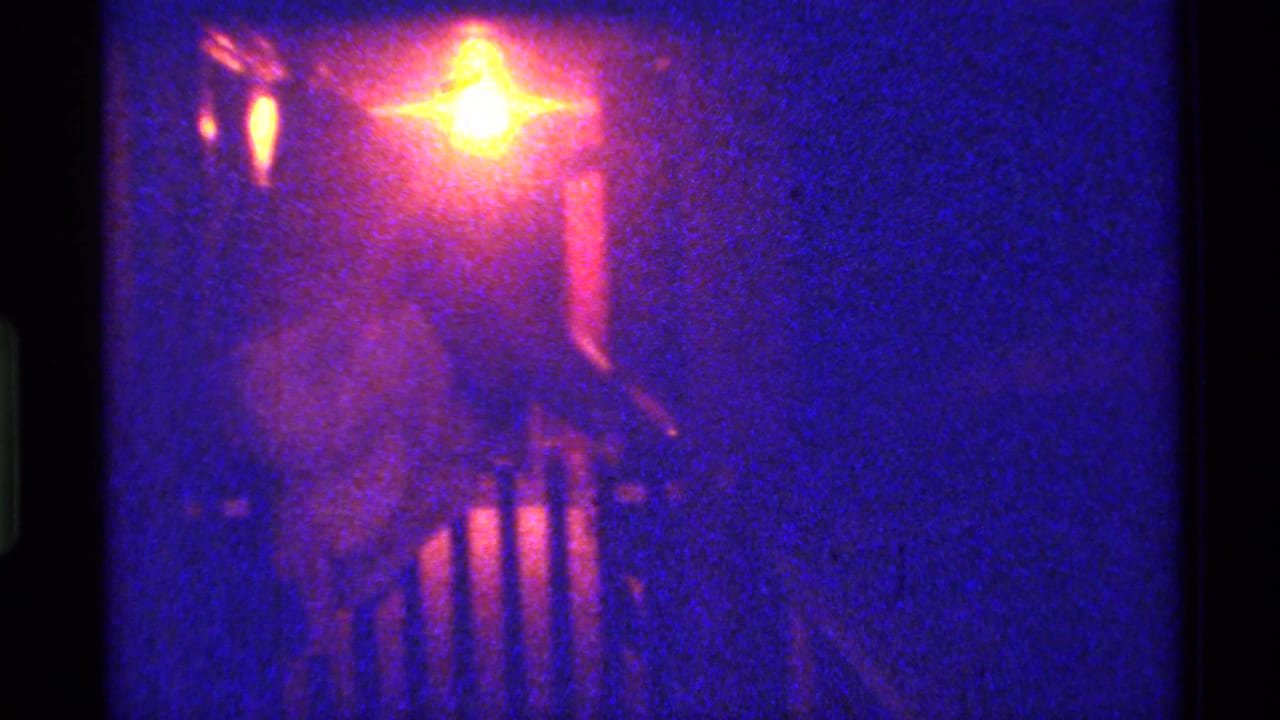 Blue-purple night frame with a bright lamp and dark railing shape.