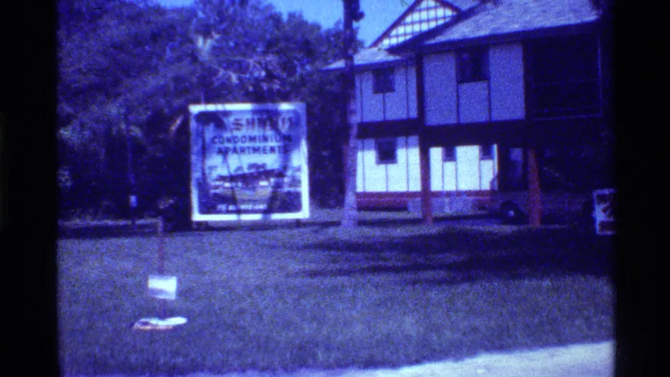 Final frame of the 1973 Florida street view, with the condominium apartments sign centered on the lawn beside the residential building exterior.