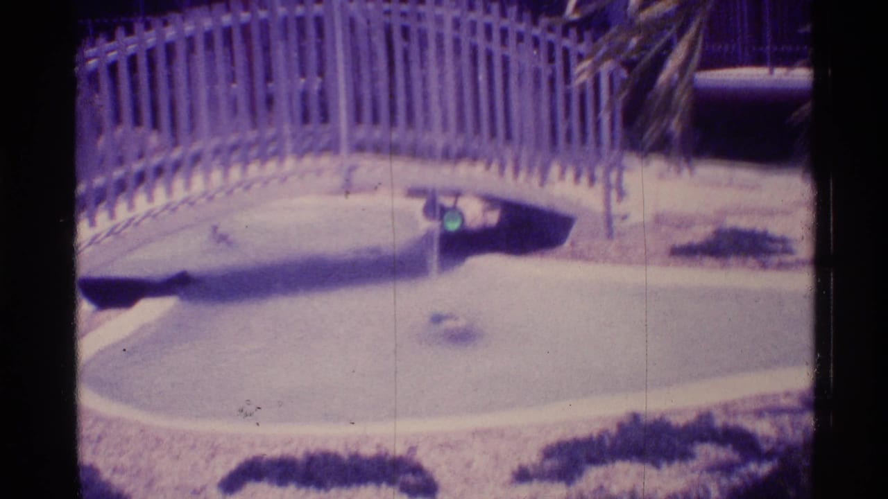 White bridge over a shallow pool with a vertical water jet near the center.