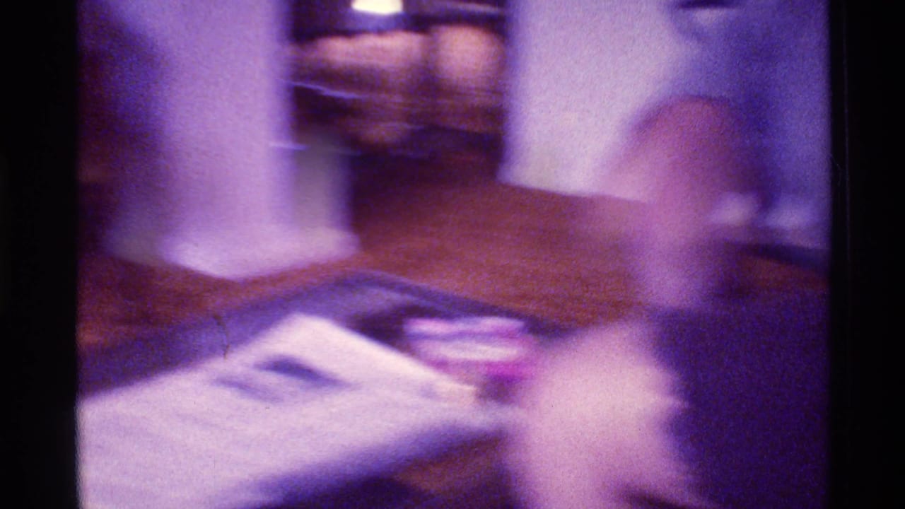 Blurred living room view with couch, table, lamp, and soft handheld motion.