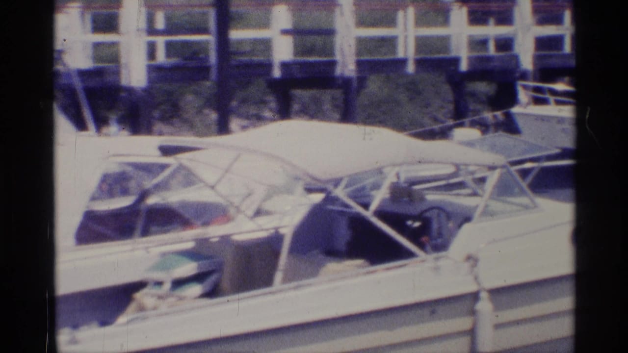 Docked motorboat seen closer, with canopy and steering area visible.