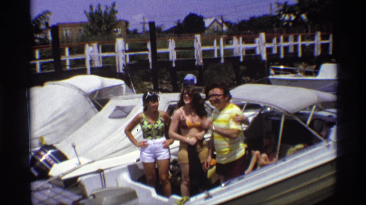 Group stands together on a motorboat, smiling toward the camera.