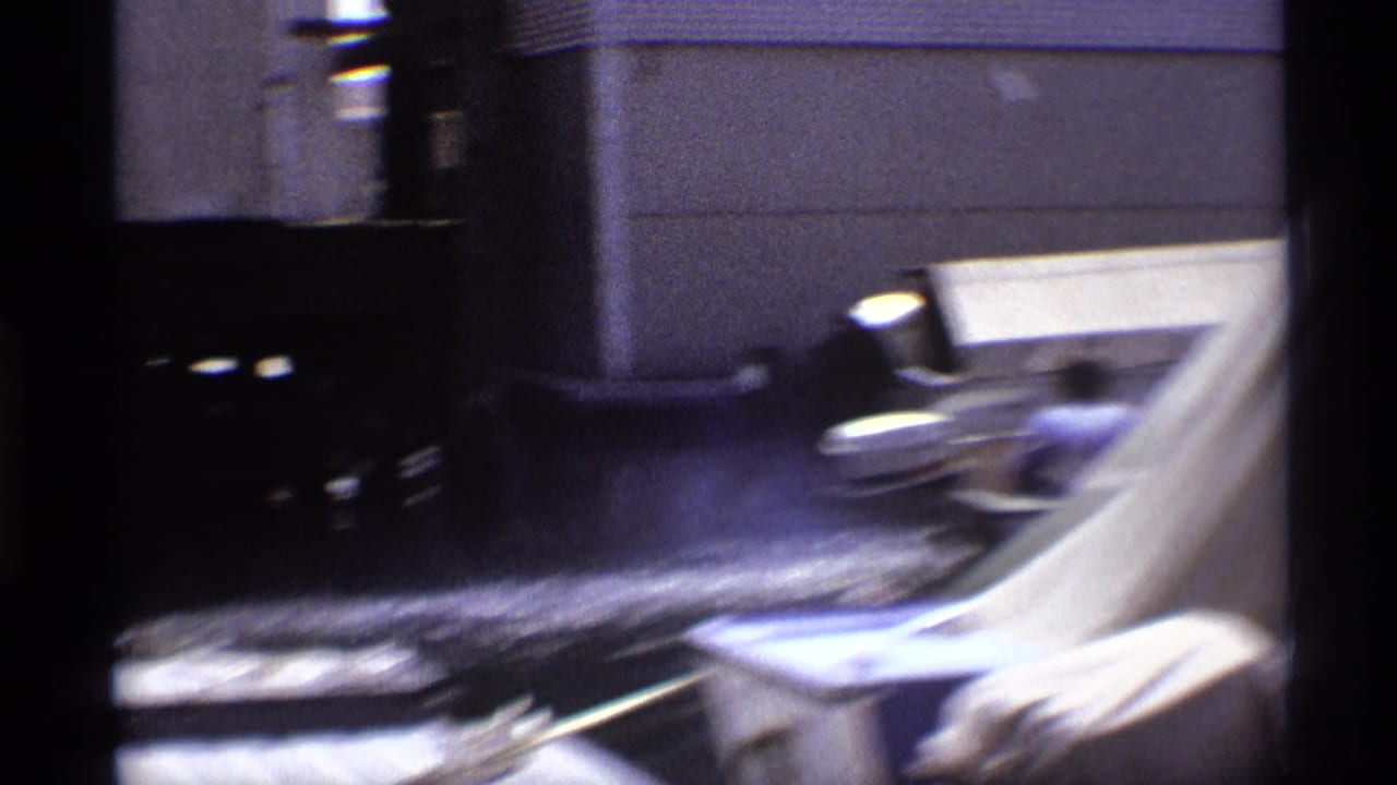 The small boat pulls away from the dock in 1973 New York footage, with spray and wake visible behind it.
