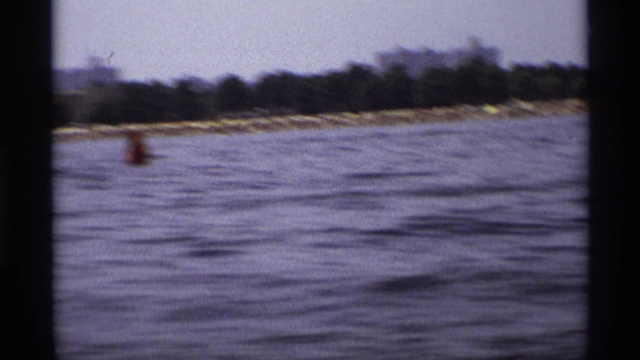Water and distant shoreline with a red buoy near the center of the frame.