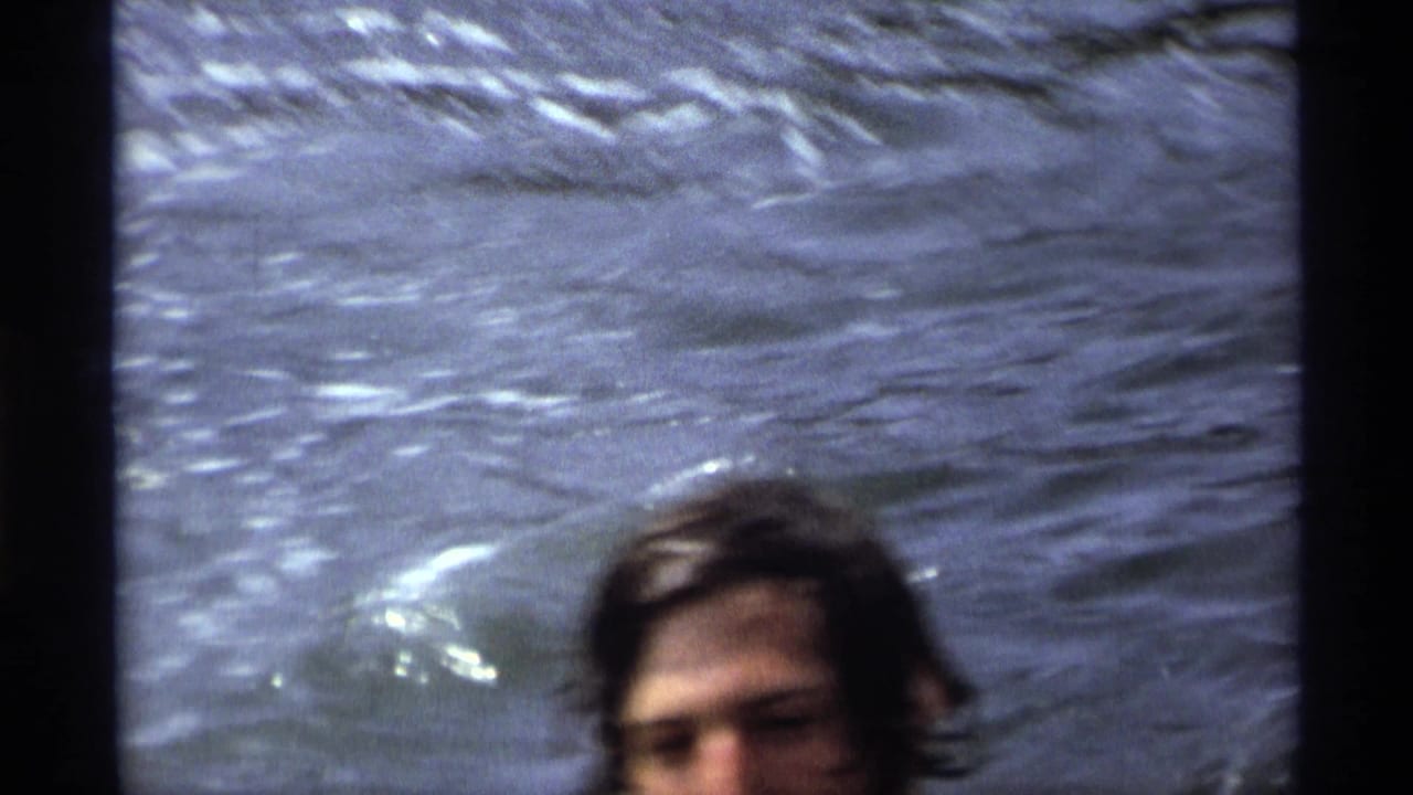 Partly cropped swimmer's head emerging from rippled water.