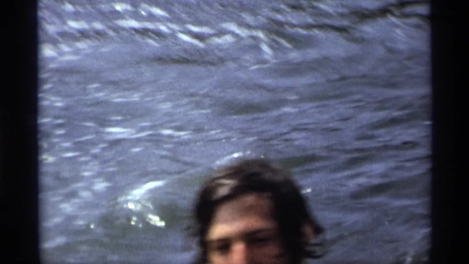 A swimmer's wet head is partly visible near the lower edge of a 1973 New York water scene.