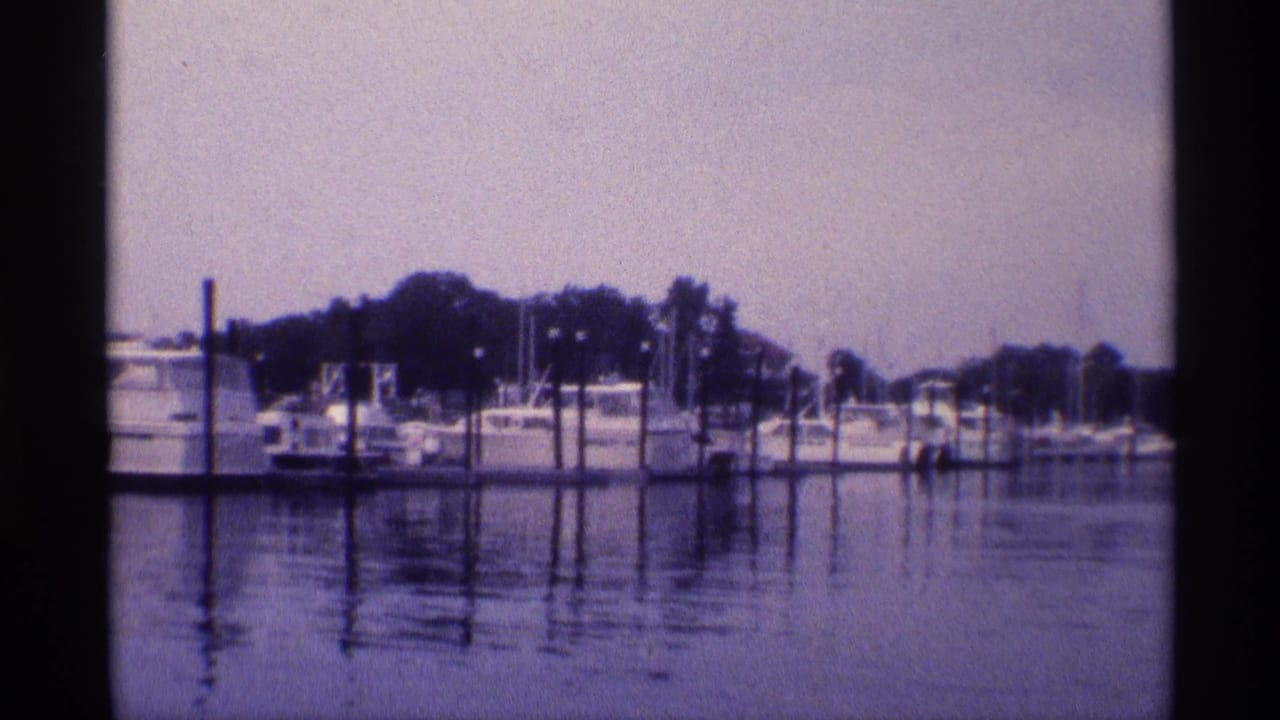 Marina boats and dock pilings reflected in still water.