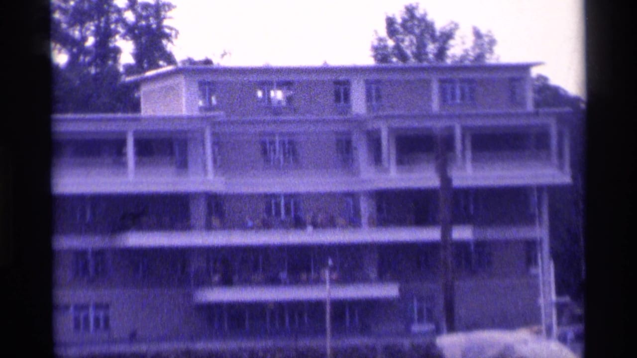 Multi-story apartment building with balconies seen from the water.