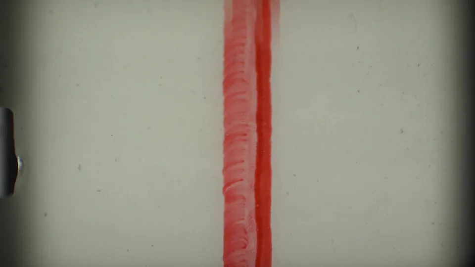 End frame shows physical film leader or exposed stock with a vertical red strip and visible film texture.