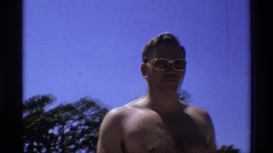 The 1973 New York frame shows the man in sunglasses from a looser angle, with blue sky and low treetops around him.