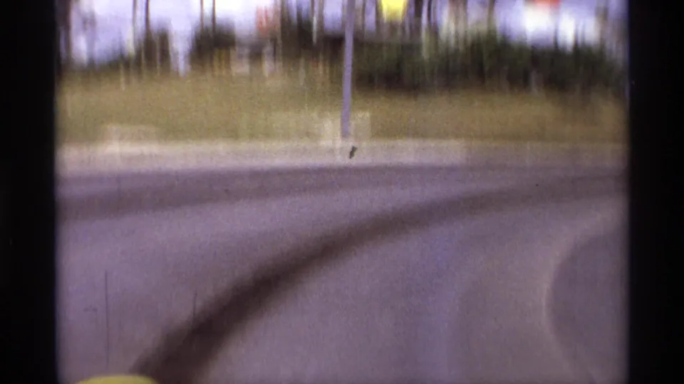 The final Orlando speedway frame shows an empty curve with sweeping tire marks, grassy infield or bank, trees, and a vertical pole.