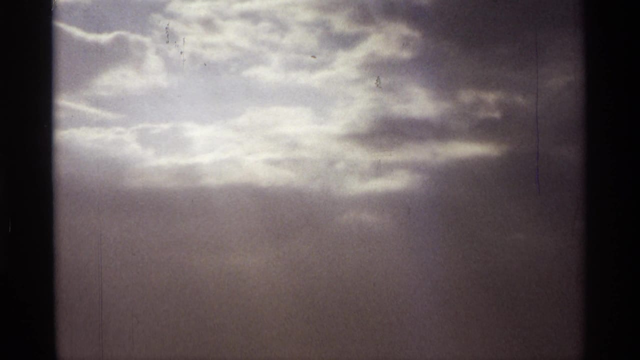 Overcast sky with a bright opening in the clouds and vertical haze.