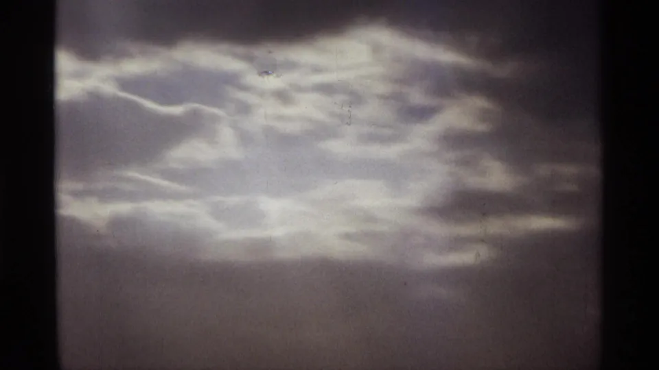 1974 Orlando 8mm frame dominated by soft cloud layers, pale diffused light, grain, and slight exposure variation.