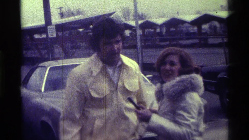 In the 1976 Kentucky clip, a woman holding a microphone stands beside a man in a beige jacket, suggesting a street interview.