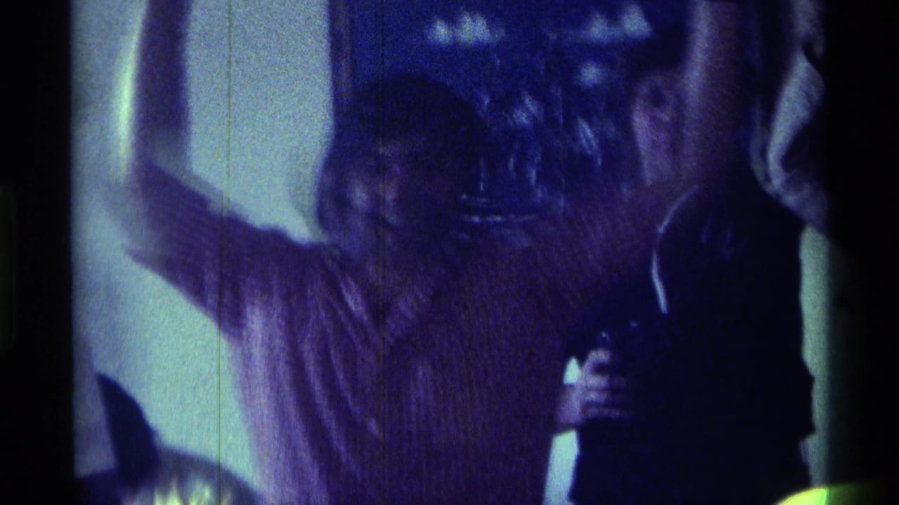 Adults indoors, one with an arm raised during a small celebration.
