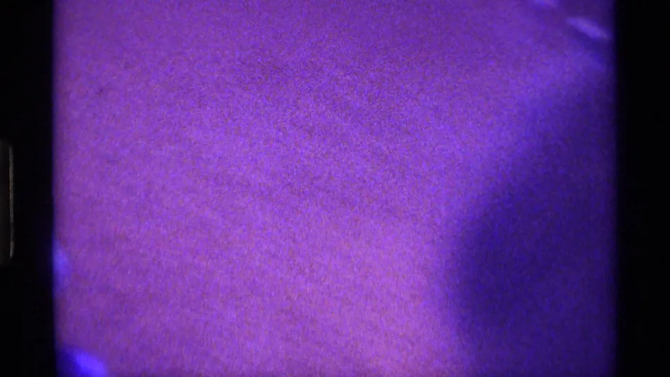Kentucky 1976 8mm frame showing a dark, purple-blue living-room area before the television becomes clear.