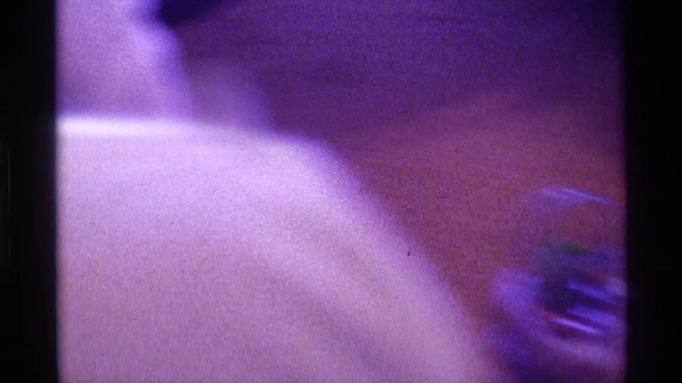 A blurred 1976 Kentucky interior frame shows a close partial person in the foreground and a glass near the right edge.