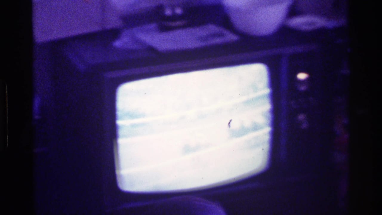 Dim room with a CRT television showing a bright horse race broadcast.