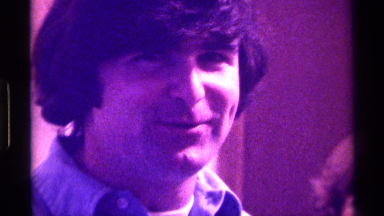 Young man in Kentucky home-movie footage smiles toward the camera in a soft, purple-tinted 1976 indoor close-up.