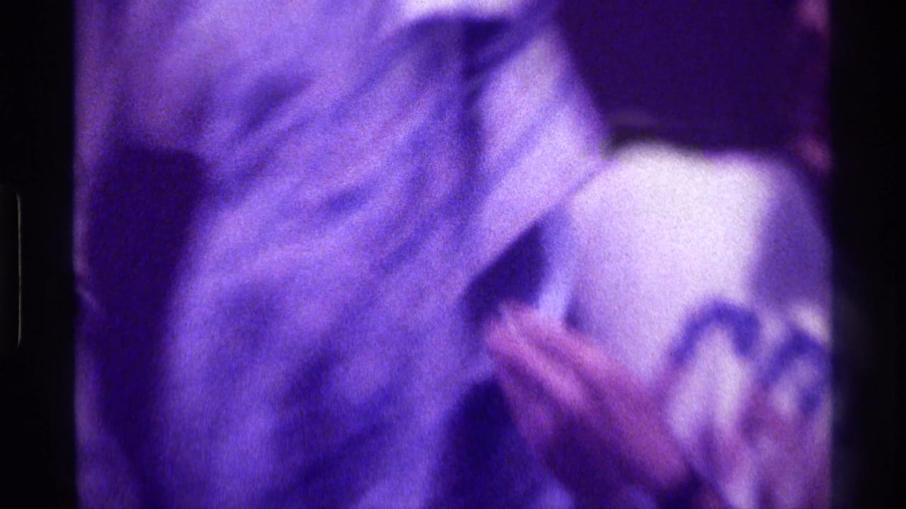 Person in a patterned jacket adjusting clothing, with hands and torso visible.