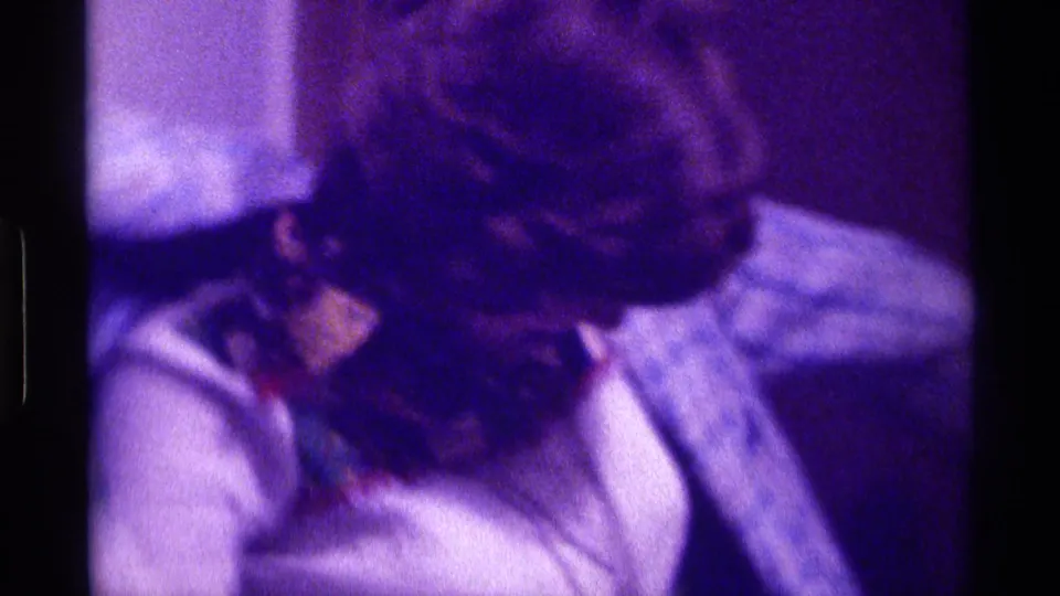 Kentucky 1976 8mm frame showing a close, soft-focus view of a visible person leaning or turning indoors.