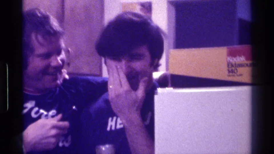 A young man laughs and covers part of his face while the female interviewer keeps the microphone near him in the Kentucky indoor scene.