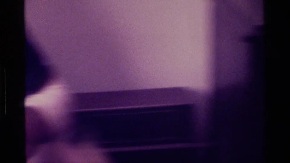 Soft 8mm frame from Kentucky in 1976 showing a boxy television set or cabinet area against an interior wall.