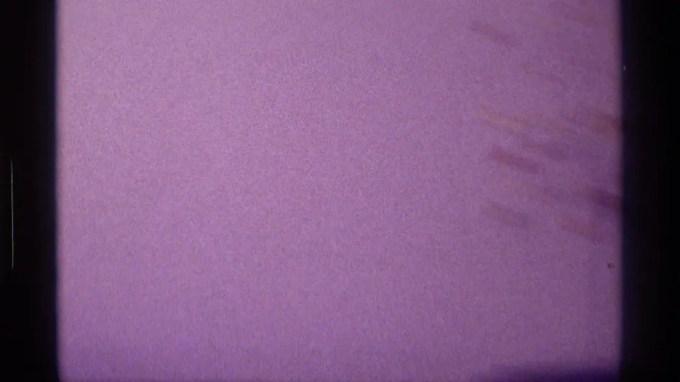 1976 Kentucky home-movie frame showing purple film cast, dark frame edges, and a mostly blank television or screen area.