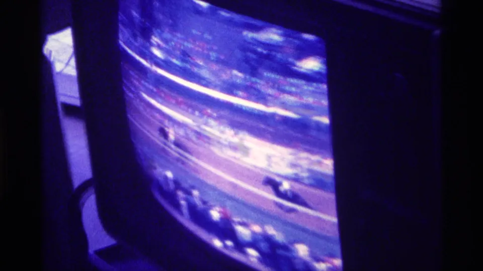 8mm frame of a 1976 Kentucky television horse race, with motion blur, screen flicker, and a dark TV frame visible.