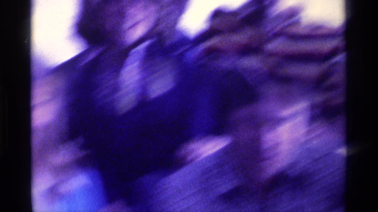 Blurred close view of adults moving in a crowded indoor space.