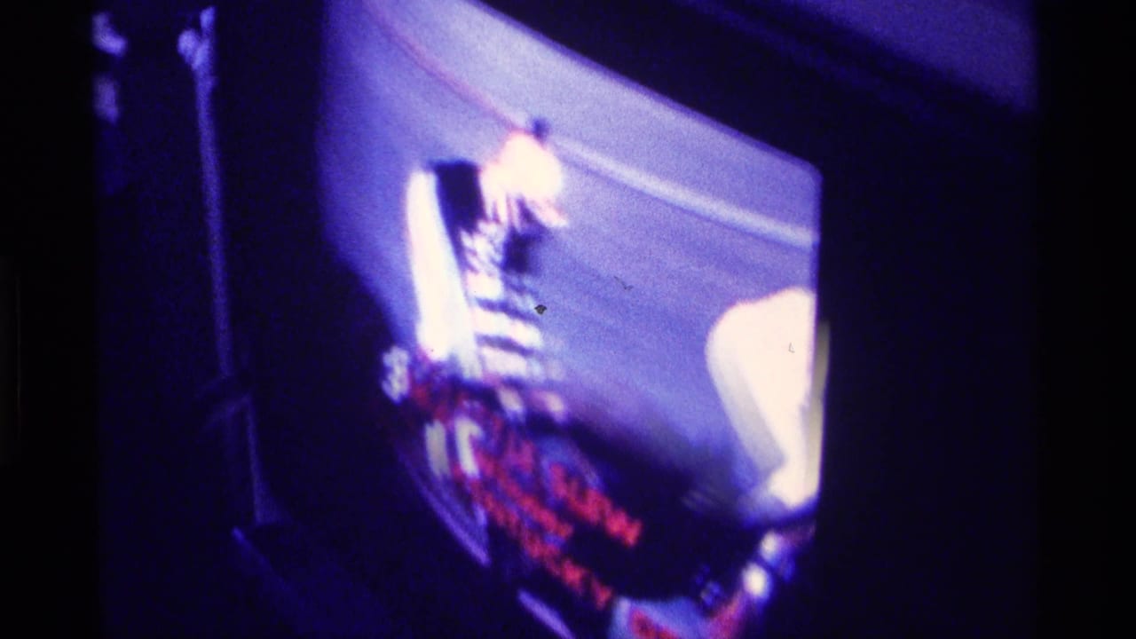 Television screen showing blurred horse-racing footage with red text overlays.