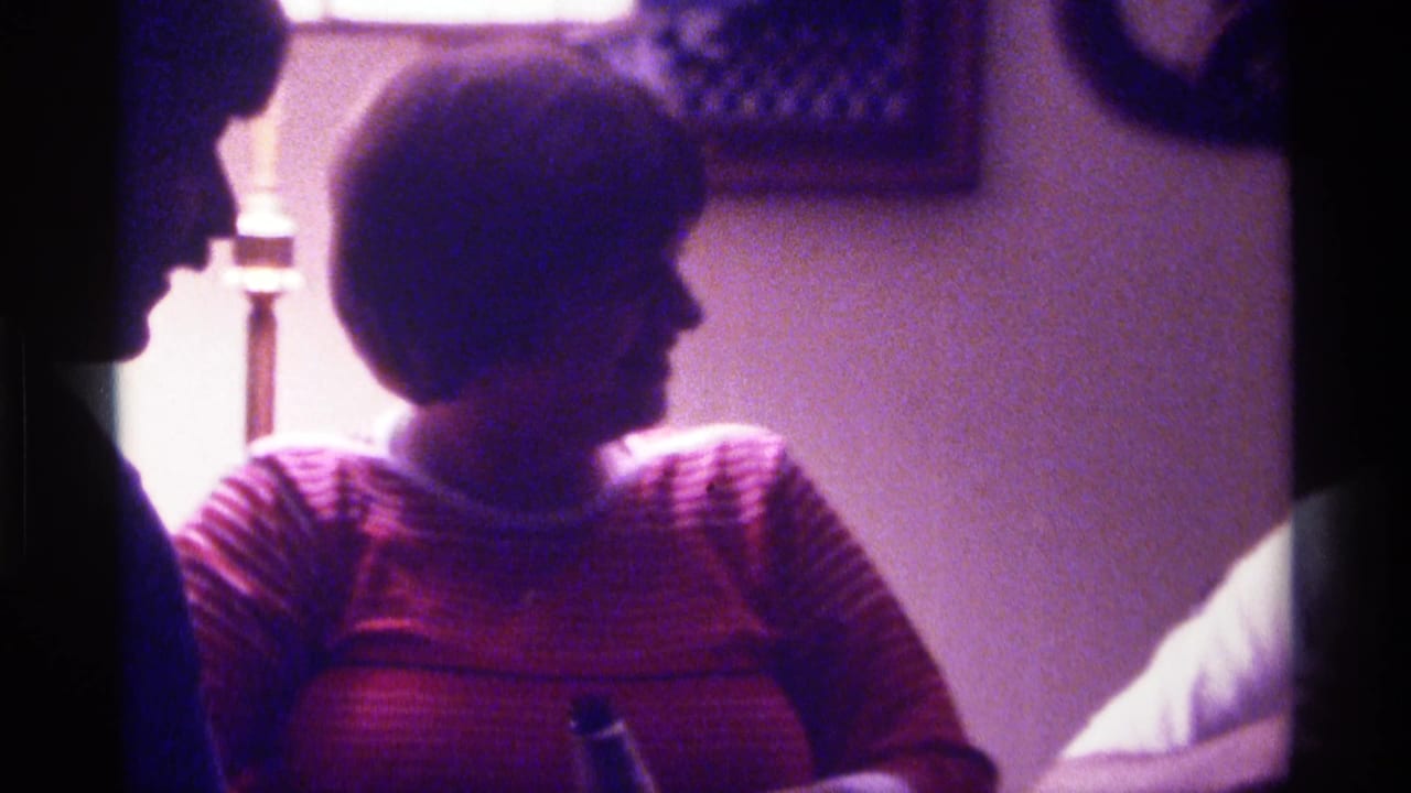 Woman in a striped sweater turns in profile beside another adult in silhouette.