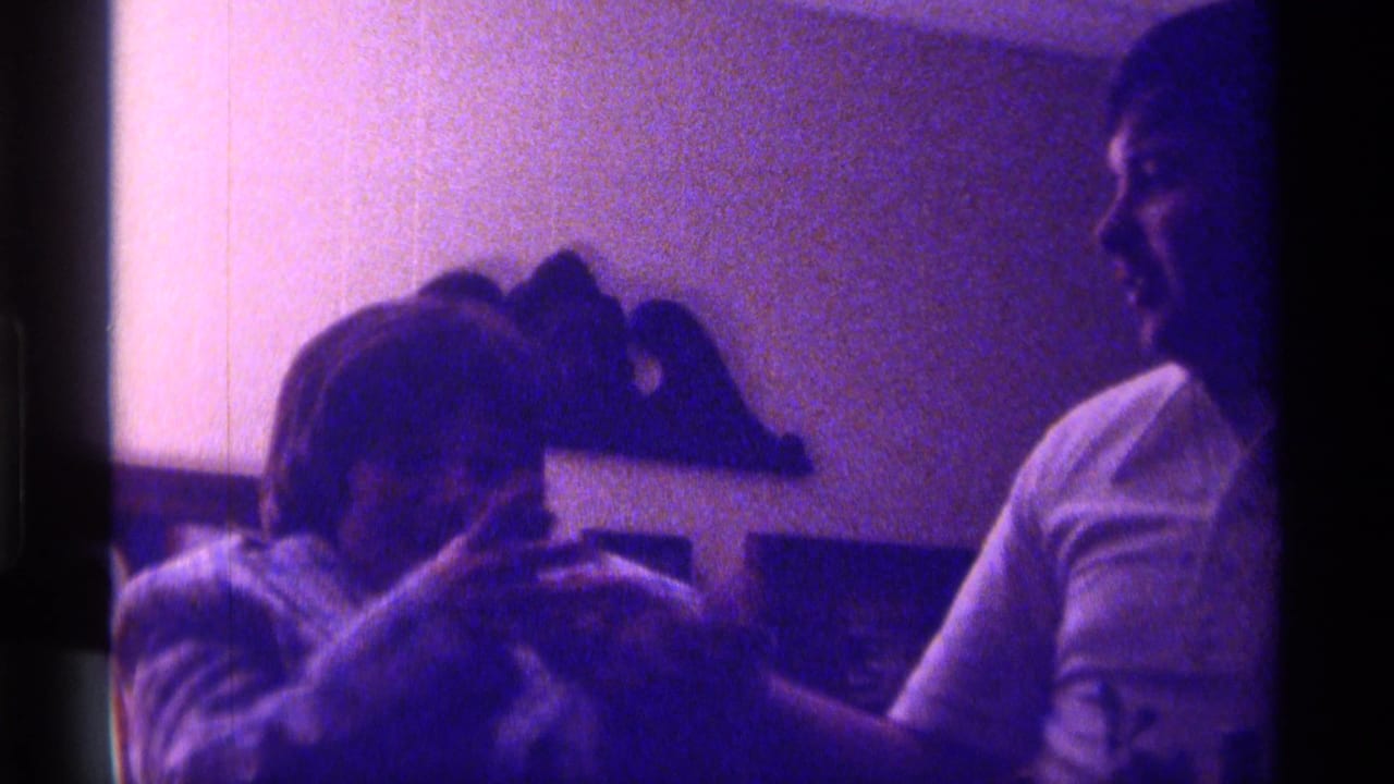 Woman and young man face each other while handling a photograph indoors.