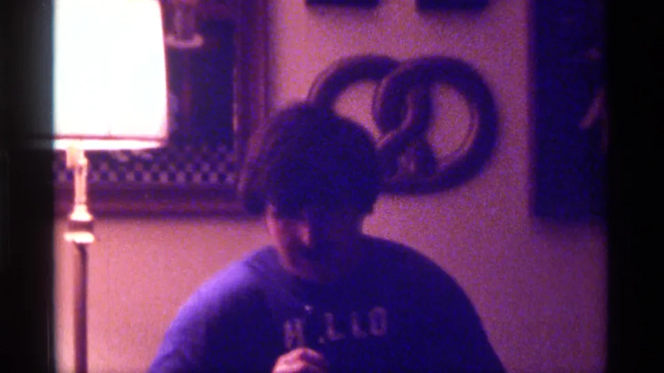 Young man in a blue shirt appears to sing into a microphone inside a Kentucky private room with a lamp, mirror, and wall decoration.