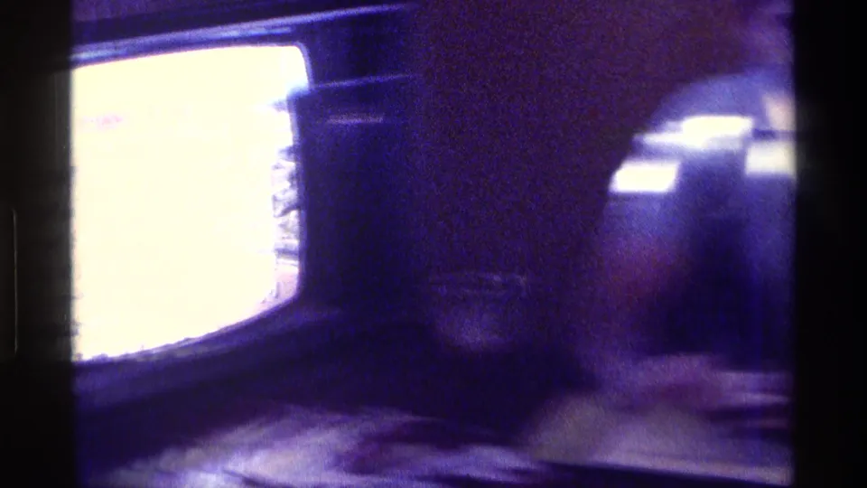 The clip cuts to a close view of a vintage television with an overexposed, distorted screen in the same home-movie sequence.