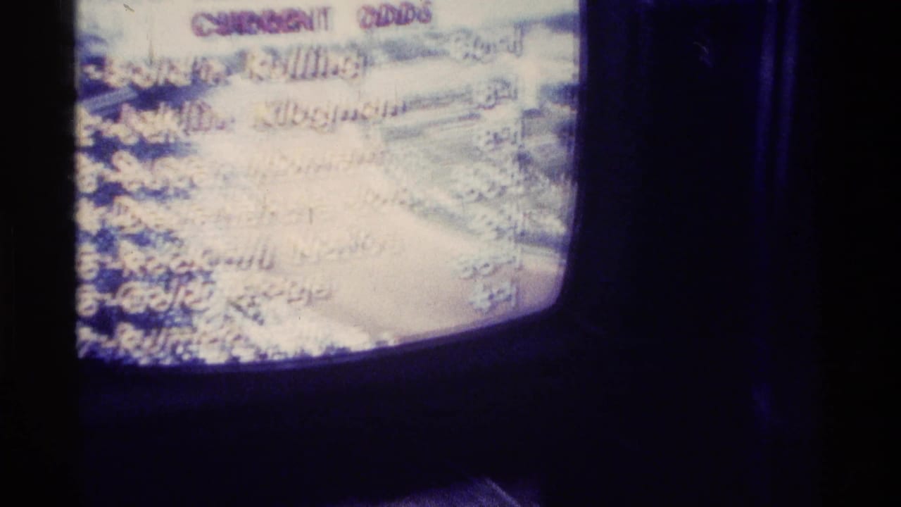 Close 8mm view of a vintage television screen in Kentucky showing racing-odds text, with some horse names only partly readable through glare and blur.