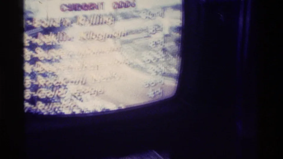 Close 8mm view of a vintage television screen in Kentucky showing racing-odds text, with some horse names only partly readable through glare and blur.