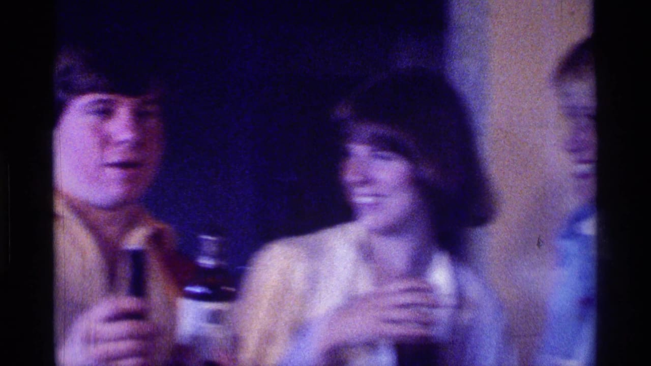Young man speaks with a microphone while a woman smiles beside him.