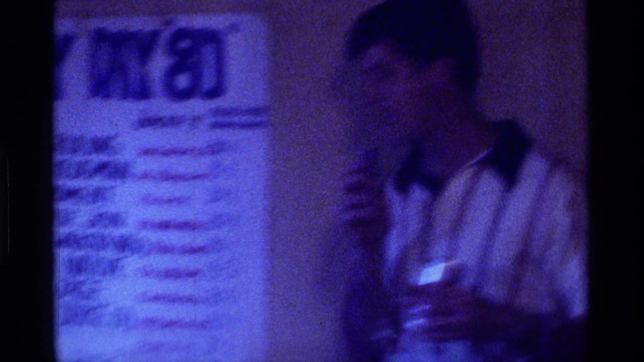 Blurred man beside a handwritten racing notice or chart.
