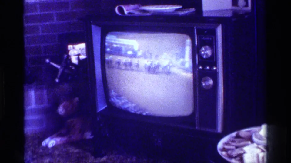 Vintage television plays a blurry broadcast in a Kentucky living room while a dog rests near the brick fireplace.