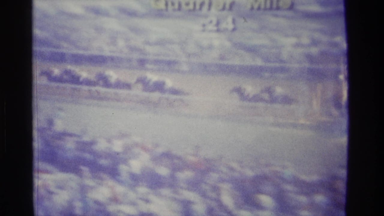 Television screen showing a blurred horse race with dark frame edges.